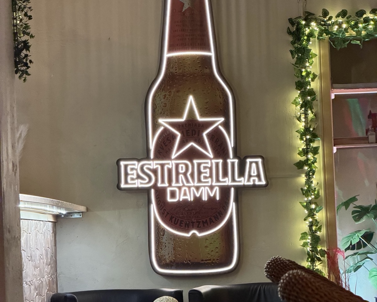 Rincón con sofás y el rótulo luminoso de Estrella Damm